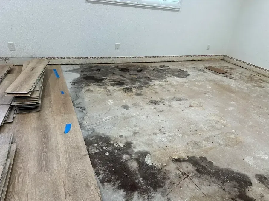 Plank flooring pulled up to expose a wet subfloor during restoration